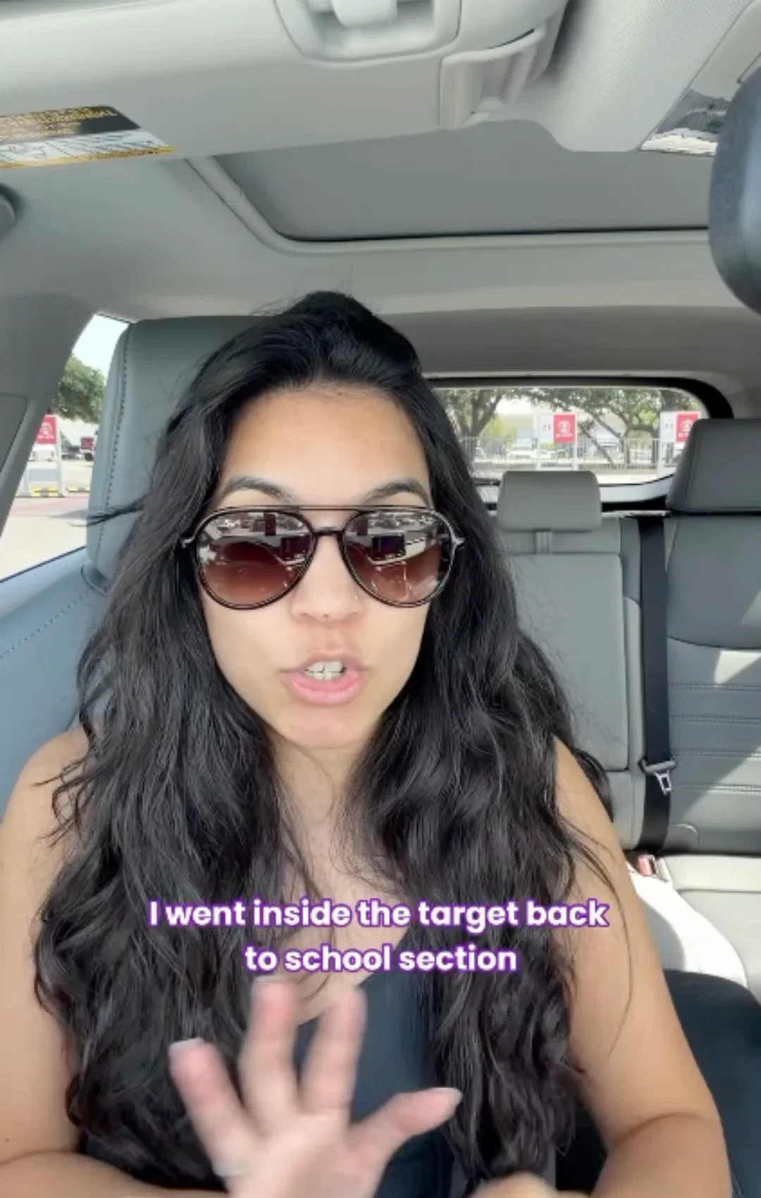 Olivia in dark sunglasses talking in her car