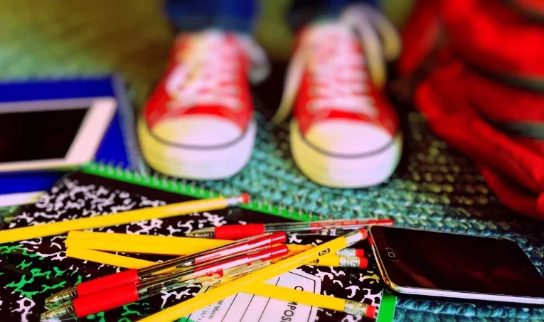 red converse and school supplies on floor