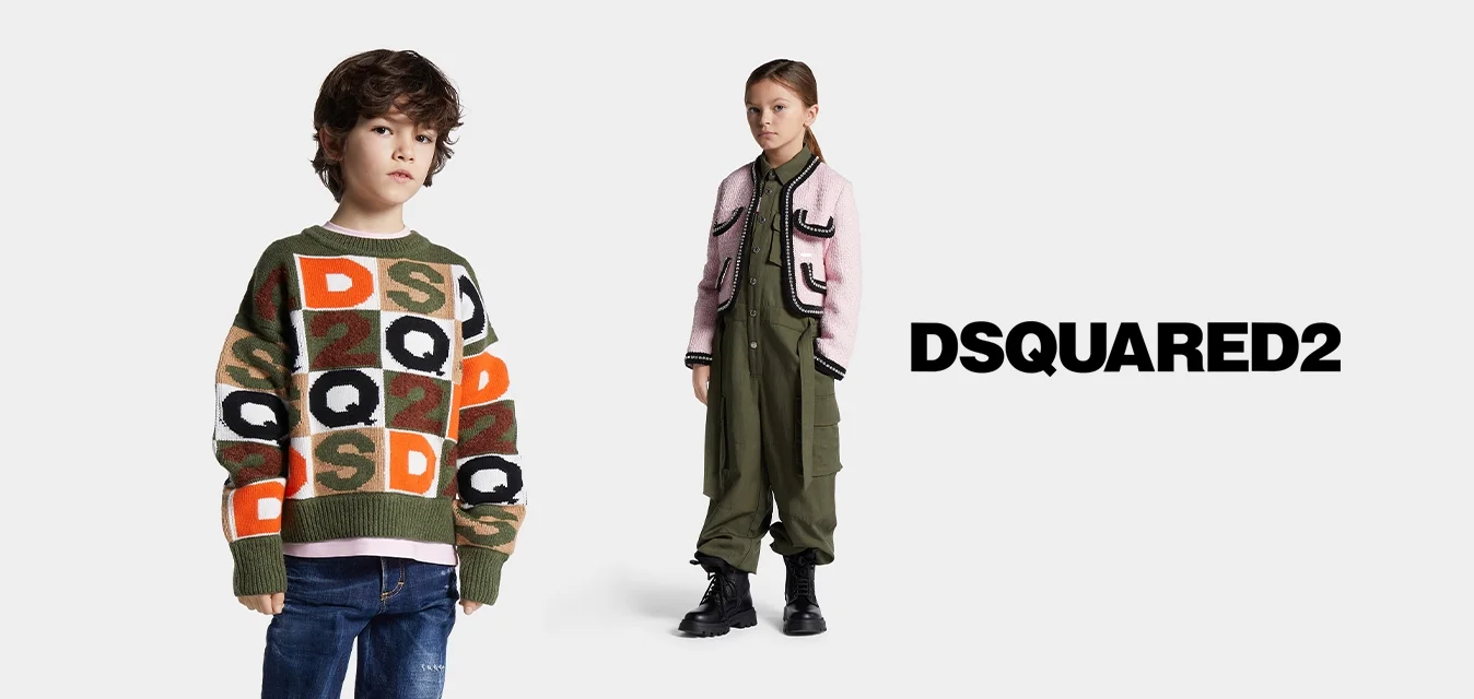Jongen met een kleurrijke, gebreide trui en spijkerbroek staat naast een meisje in een olijfgroene jumpsuit en een roze vest met zwarte laarzen op een witte achtergrond.