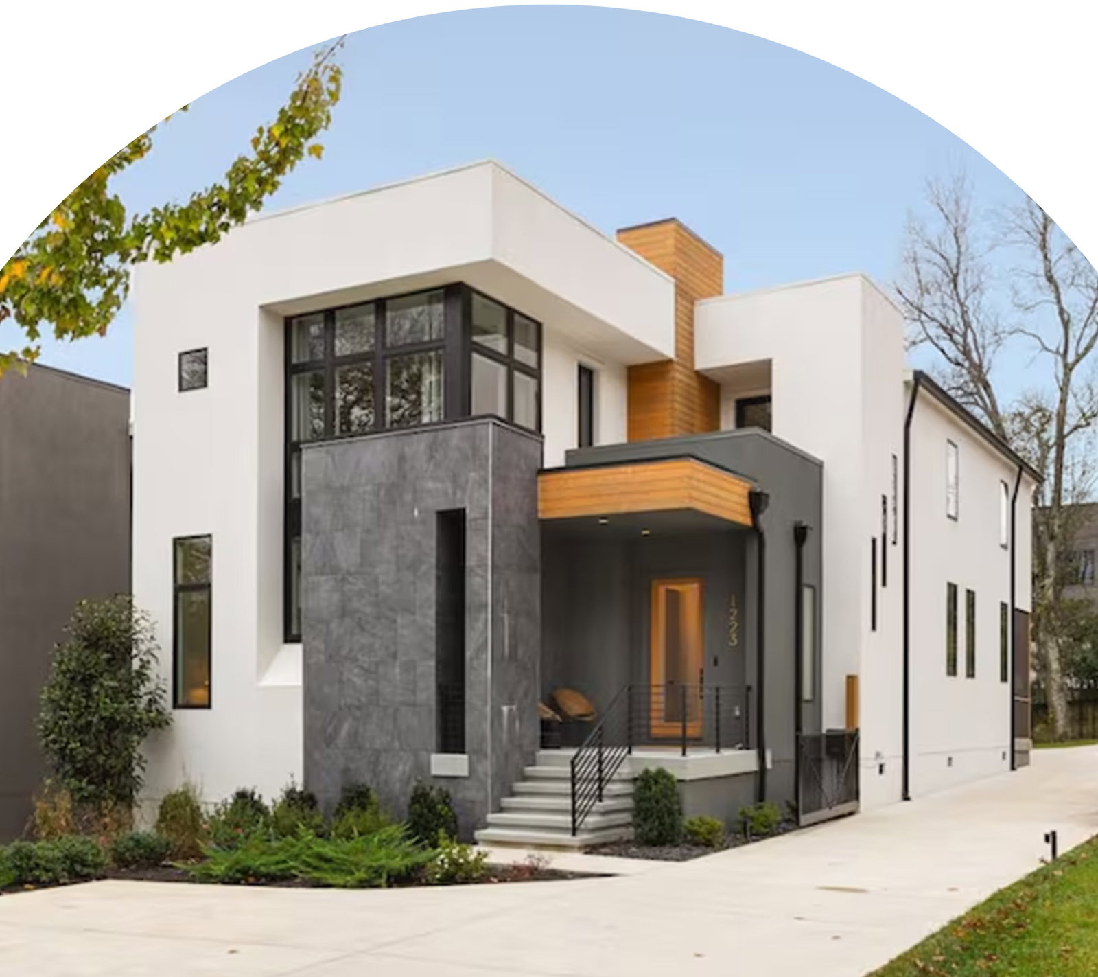 Two-story home with geometric design, large windows, and clean lines.