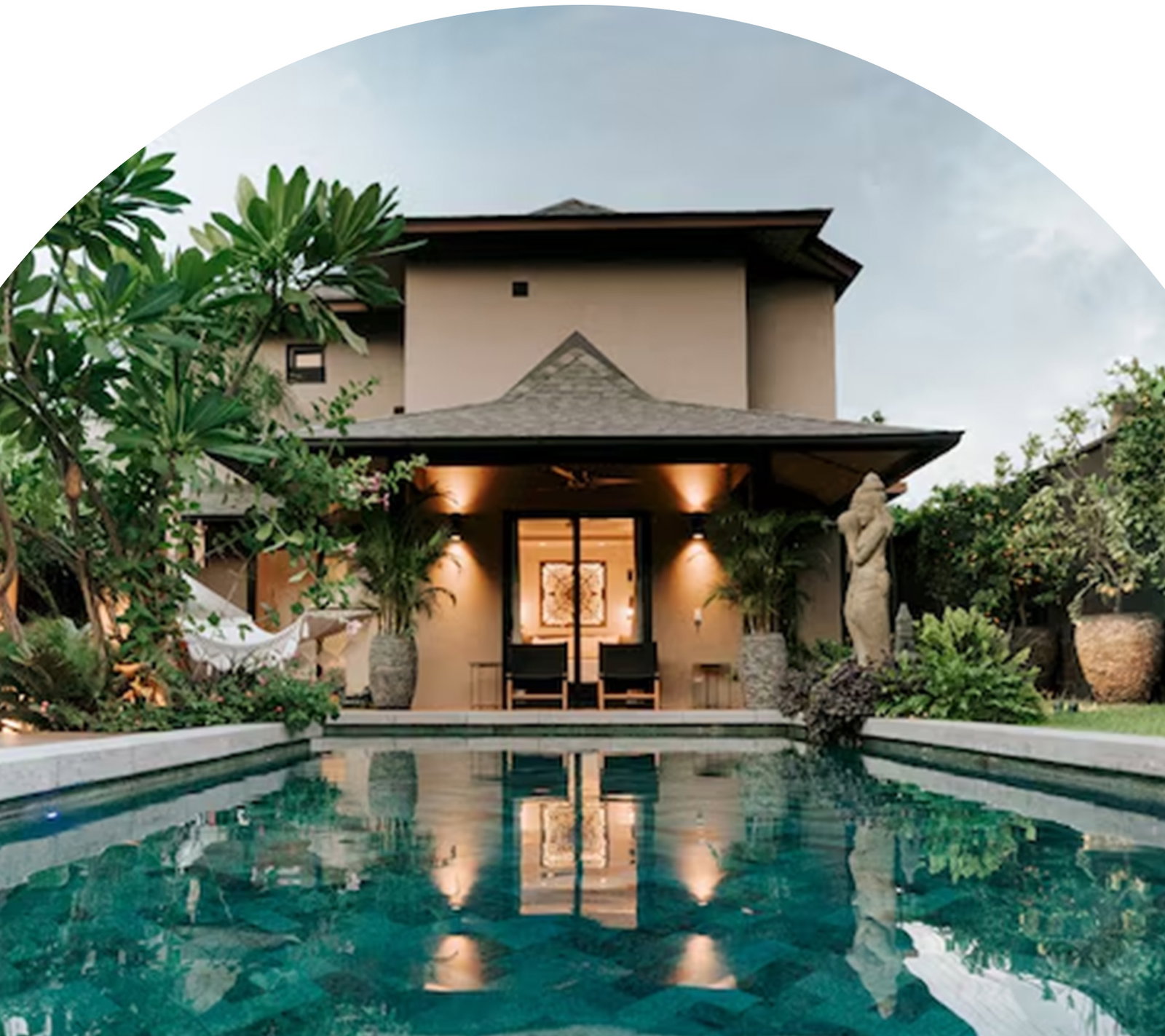 Home with pool, tropical landscaping, and covered outdoor seating area.