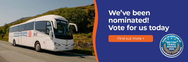 A coach bus parked on a scenic road, surrounded by greenery, promoting a travel award nomination.