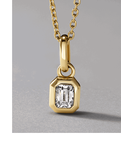 Yellow gold emerald-cut bezel-set diamond pendant necklace.