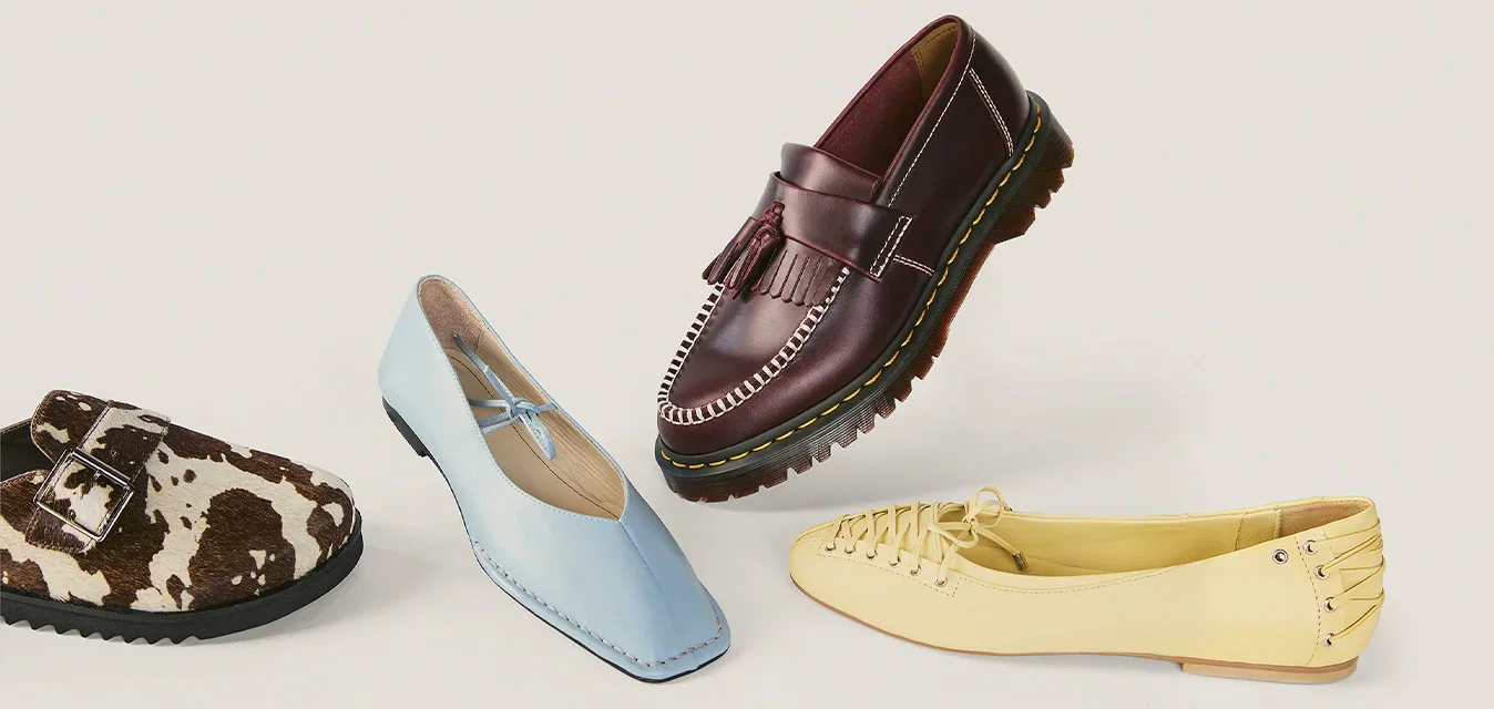 Vier Damenschuhe in verschiedenen Stilen und Farben: braun-weiss Slip-Ons, hellblaue Ballerinas, dunkelbraune Loafers und gelbe geschnürte flache Schuhe.