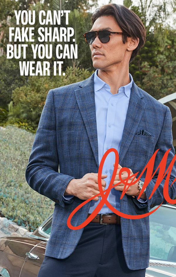 Model wearing a blue plaid blazer, light blue shirt, dark pants, and sunglasses beside a classic car. Text reads: 