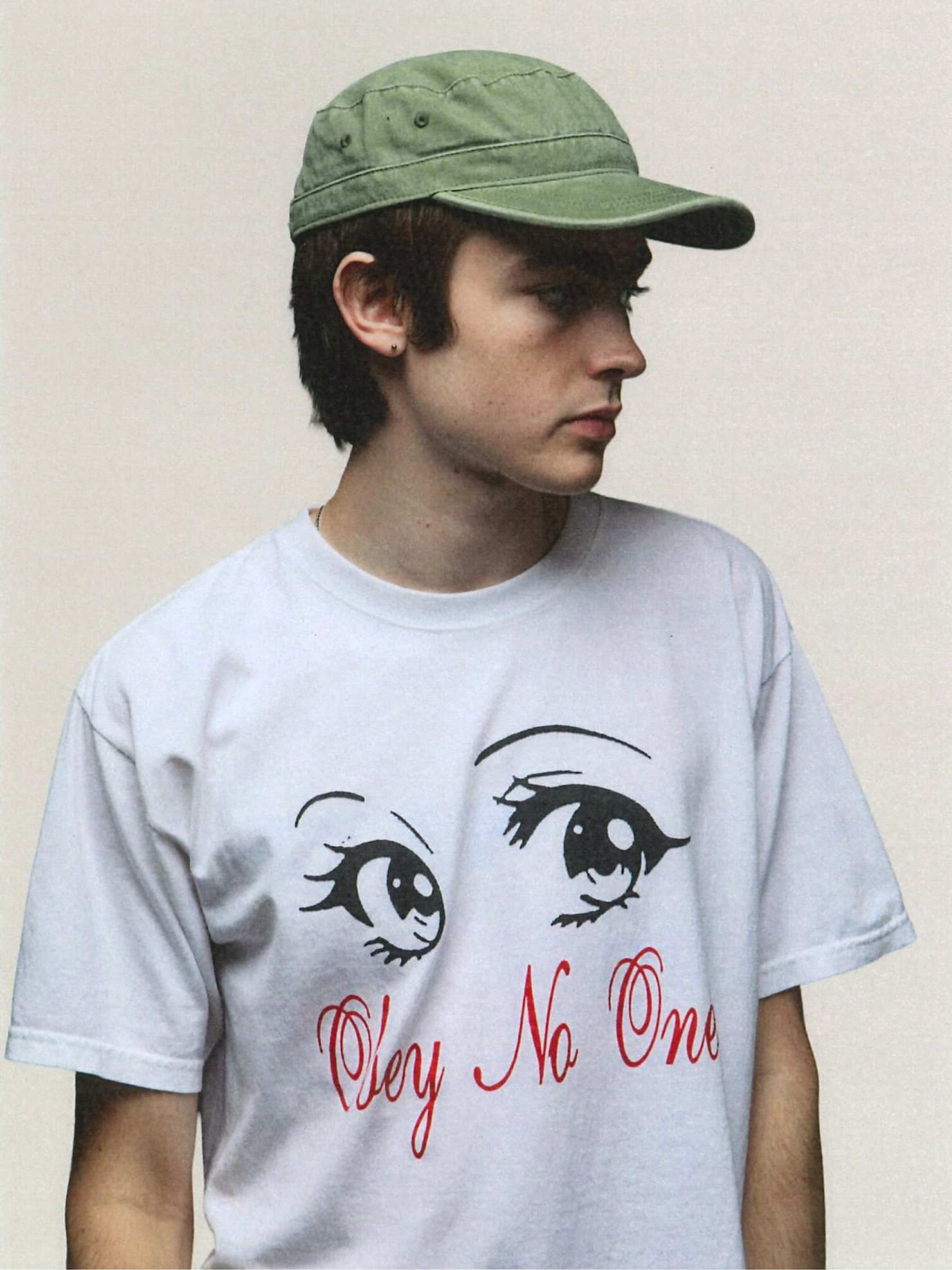 Male model wearing white t shirt with eyes and red writings