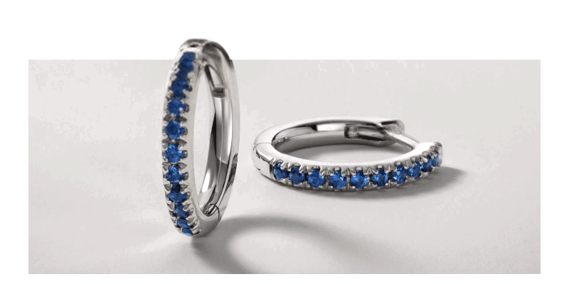 Blue sapphire hoop earrings in a silver-tone setting.