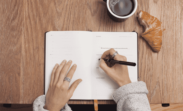Person writing in a genealogy research log.