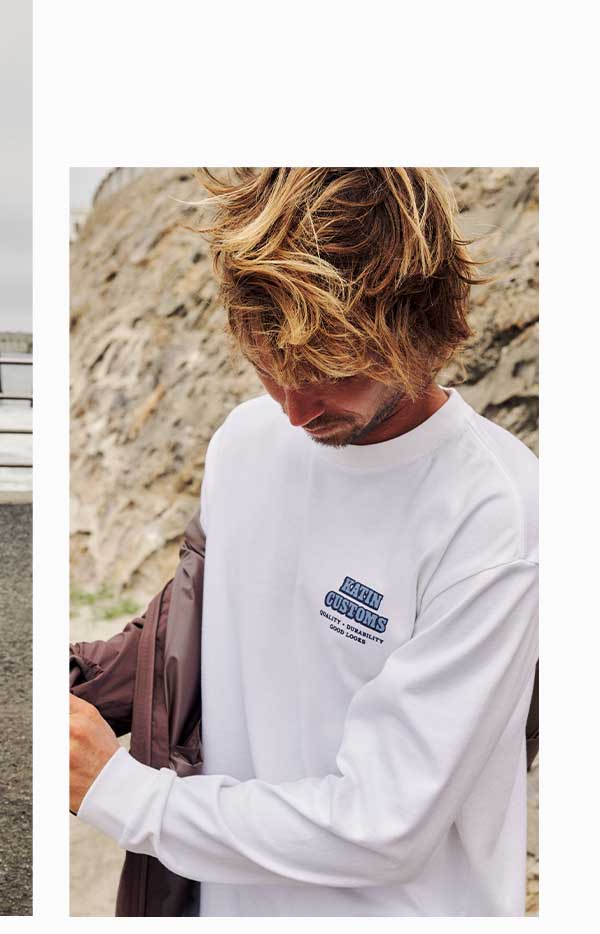 Model taking off jacket wearing the Lorry Box Fit LS Tee in white.