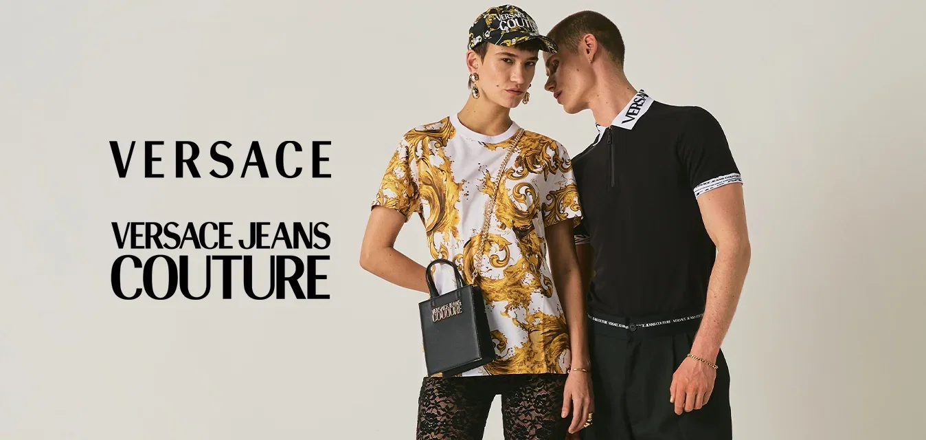 Zwei Models posieren: eines in goldgemustertem Hemd, schwarzen Spitzenhosen, Baseballkappe und hält eine kleine schwarze Tasche; das andere in schwarzem Top und blauen Hosen.
