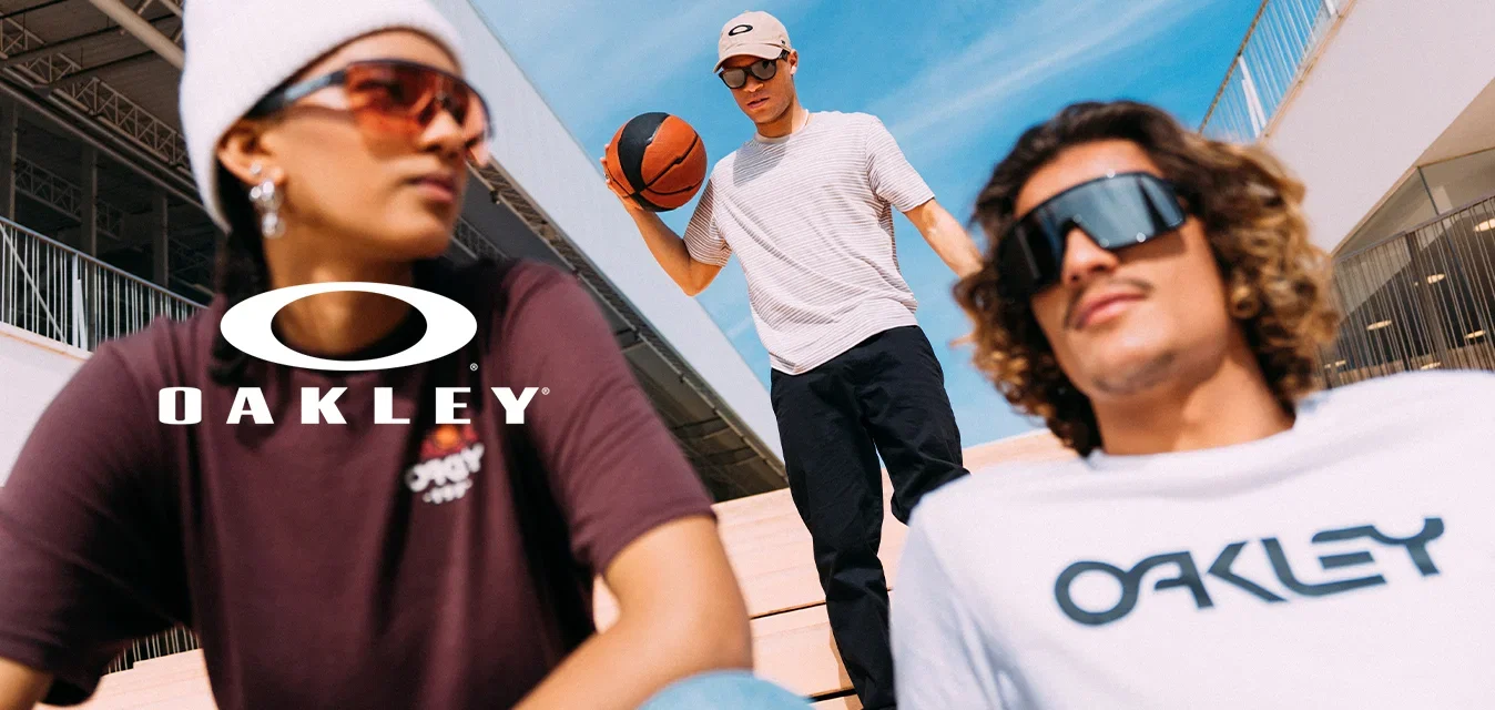 Drei junge Leute draussen auf der Treppe, einer hält einen Basketball, alle tragen Sonnenbrillen und lässige Streetwear unter klarem blauem Himmel.