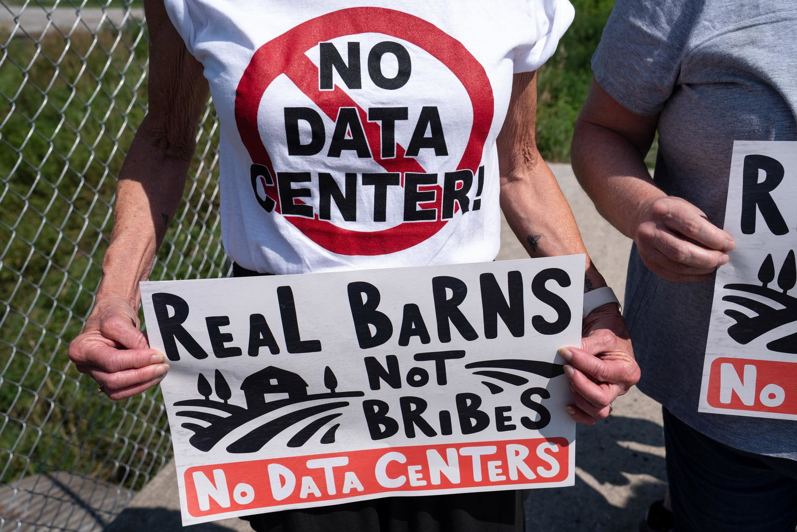 An attendee holds a sign at an anti-data center protest.