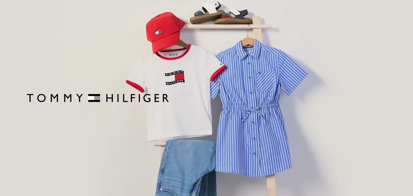 Rote Kappe, weißes T-Shirt, blaue Jeans, blau gestreiftes Kleid und Sandalen auf einer Holzleiter vor einer schlichten Wand ausgestellt.