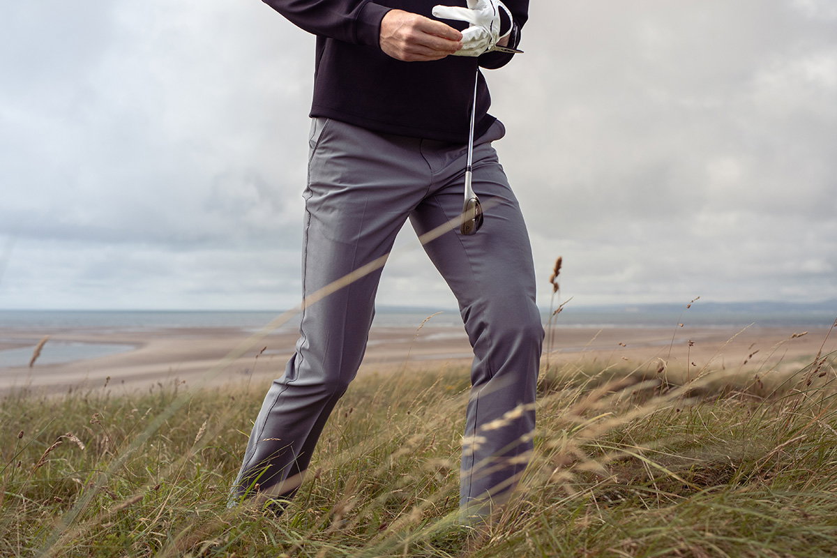Golfer walking through long grass 