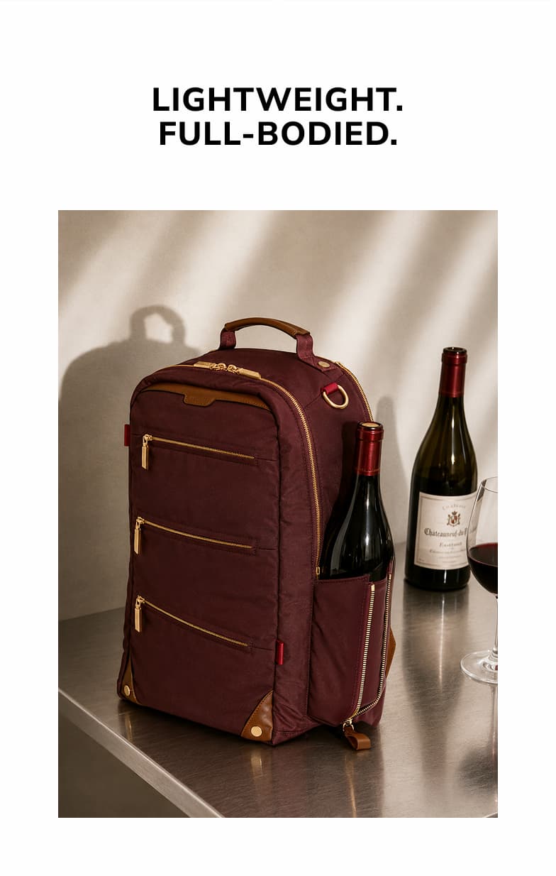 Wine-colored nylon backpack with gold hardware and brown leather accents displayed beside wine bottles.