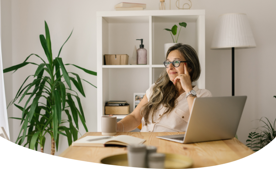 Person sitting at desk, looking out window, smiling