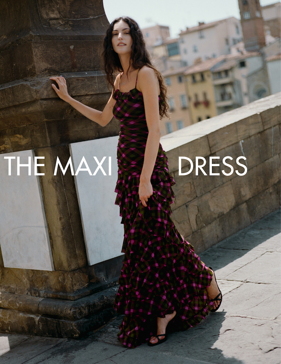 Model standing resting against pillar in Primrose Gown