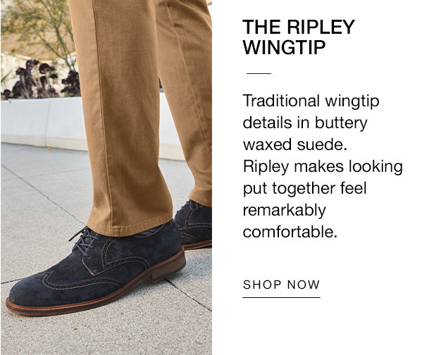 Close-up of navy suede Ripley Wingtip shoes worn with tan pants. Text reads: 