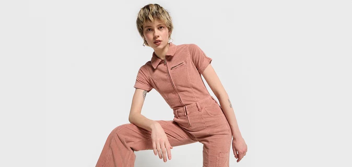 Rosa Baumwoll-Overall mit kurzen Ärmeln, einem Reißverschluss vorne und einer taillierten Passform. Lockere Beine mit Taschen und einer strukturierten Oberfläche.