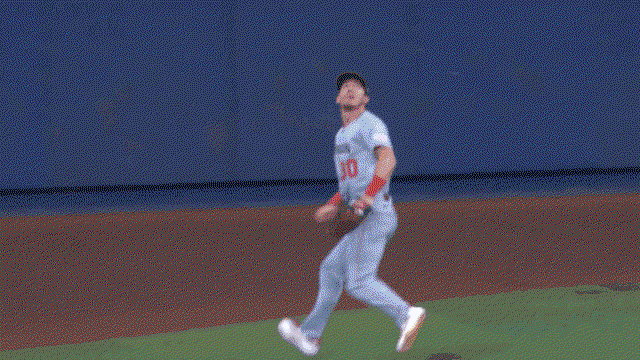An animated gif of Jacob Young climbing the outfield wall to make a catch