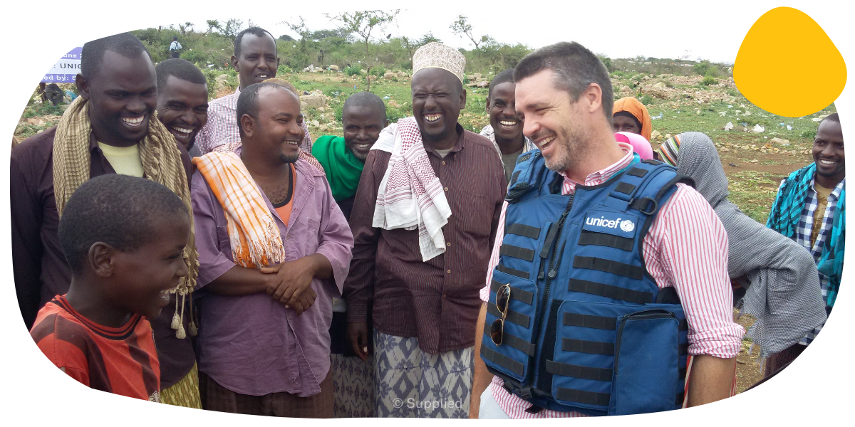 A smiling UNICEF worker speaking with a community 