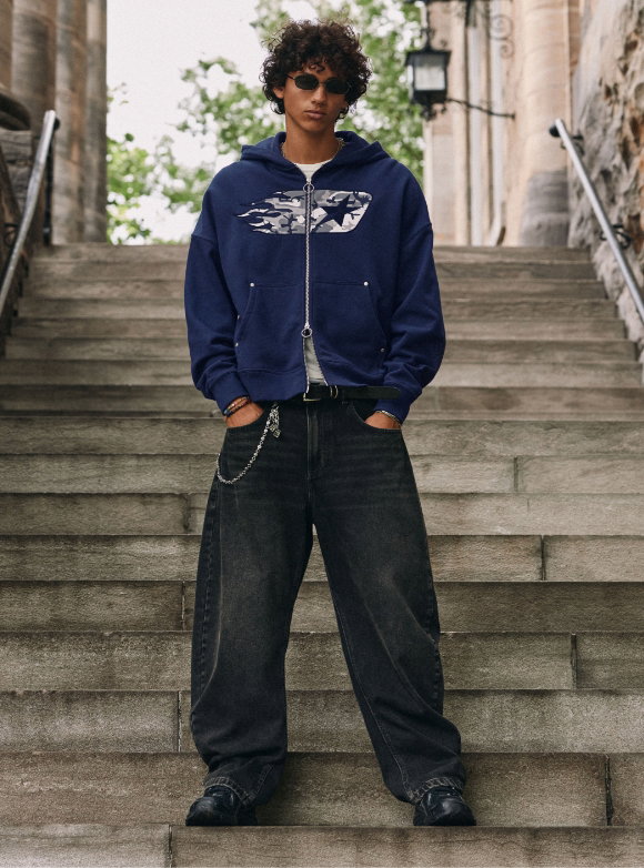 A young man wearing a pair of Djab exclusive baggy jeans in a faded black wash. 