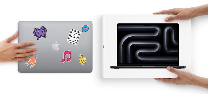 A hand rests on a silver MacBook with colorful stickers while two hands hold a MacBook box below on a white background.
