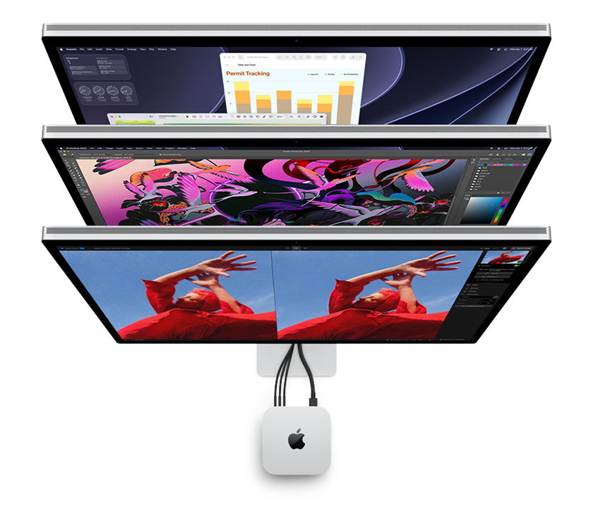 Three stacked displays are arranged vertically, each showing different creative workspaces, with cables running to a silver Mac mini centered beneath them.
