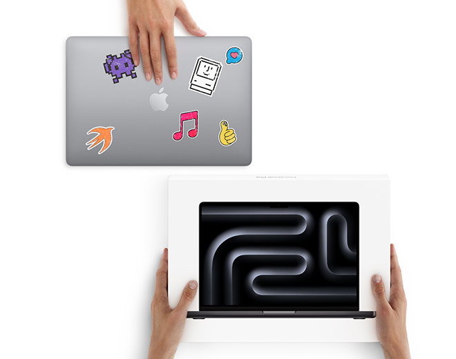 A hand rests on a silver MacBook with colorful stickers while two hands hold a MacBook box below on a white background.