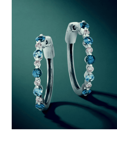 White gold hoop earrings with alternating blue sapphires and diamonds.