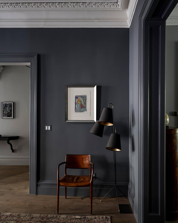 Dark grey painted room featuring a leather accent chair and black floor lamp against a dramatic charcoal wall, showcasing the depth and richness of Down Pipe No.26. 