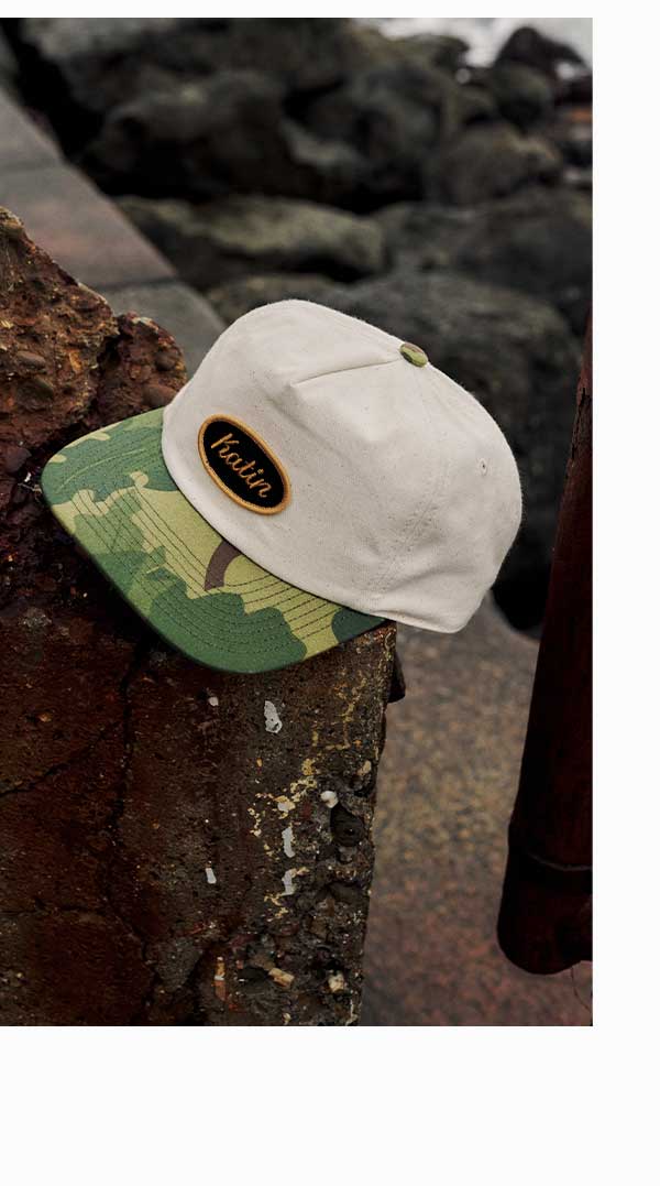 Roadside Hat sitting on rusty wall in front of rocks.