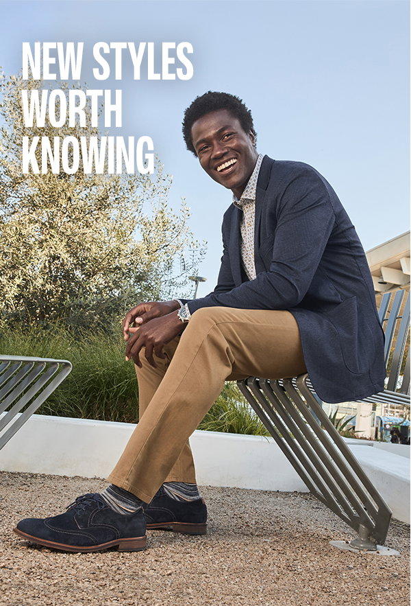 Model wearing a navy blazer, patterned shirt, tan pants, and navy dress shoes while seated outdoors. Text reads: 