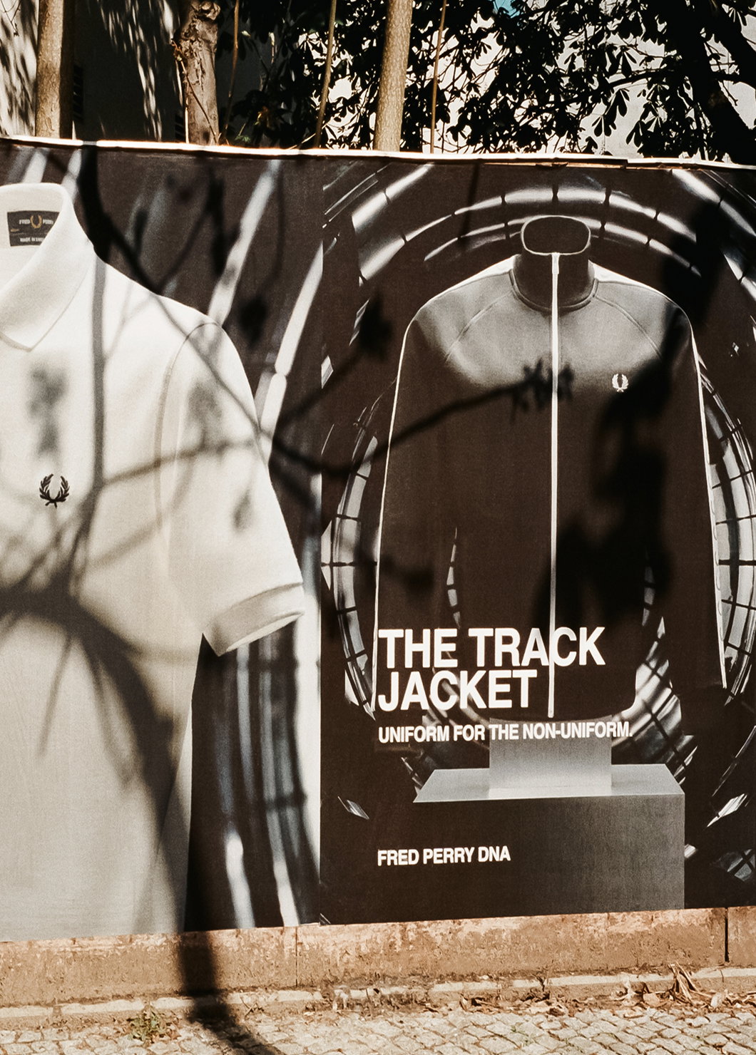 A public wall showcasing the Fred Perry Taped Track Jacket