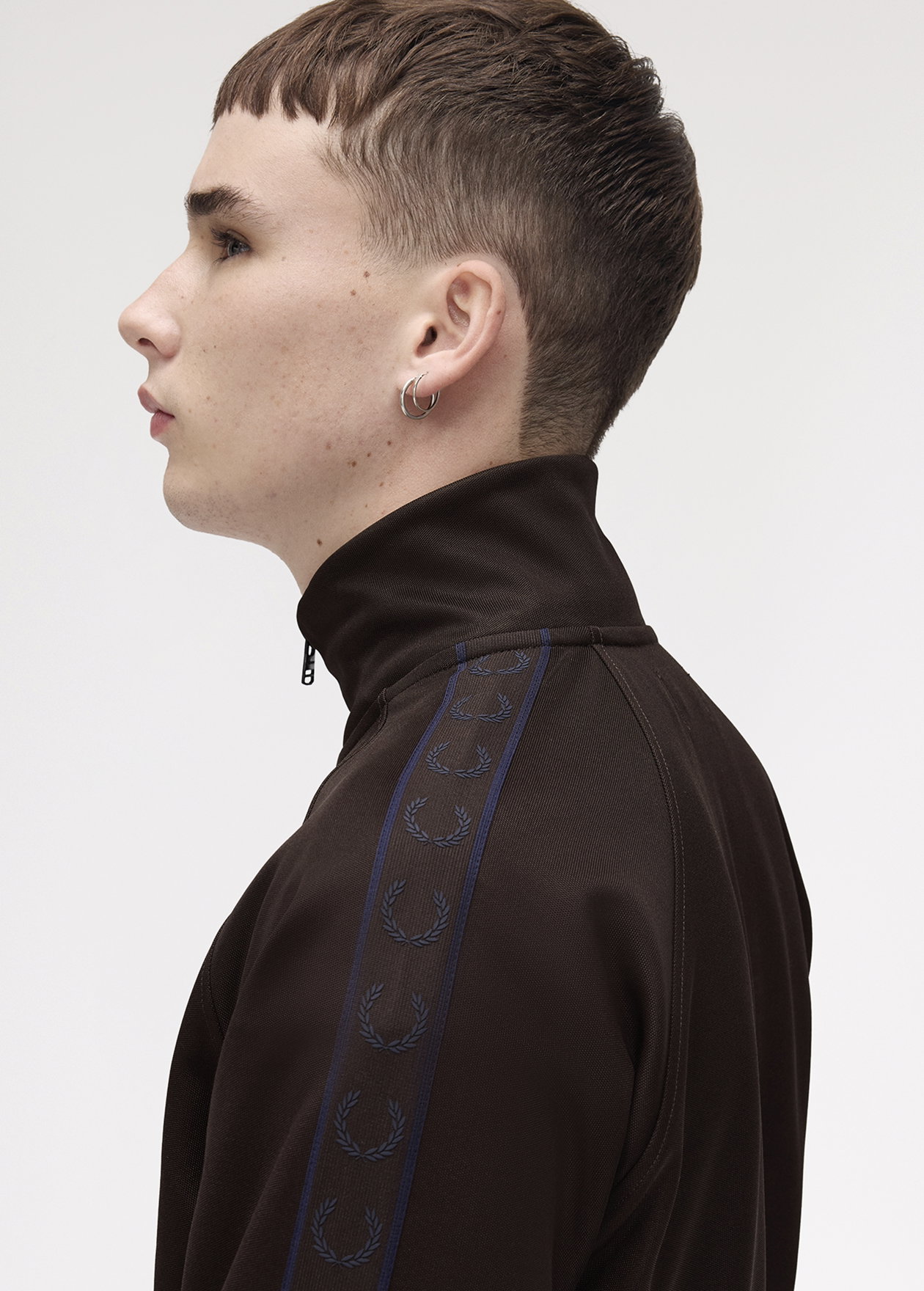 A male model wearing a Fred Perry Contrast Tape Track Jacket in Rich Brown