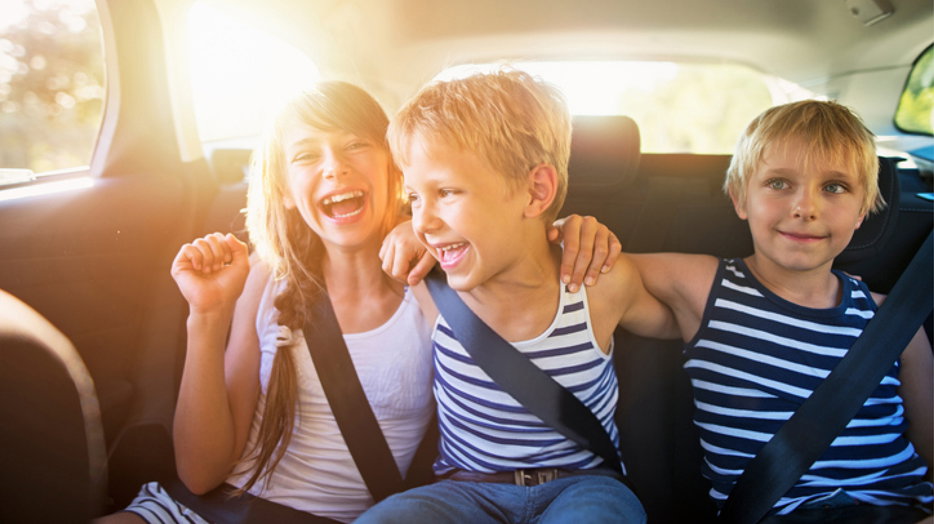 Kids having fun in the back seat of a vehicle.