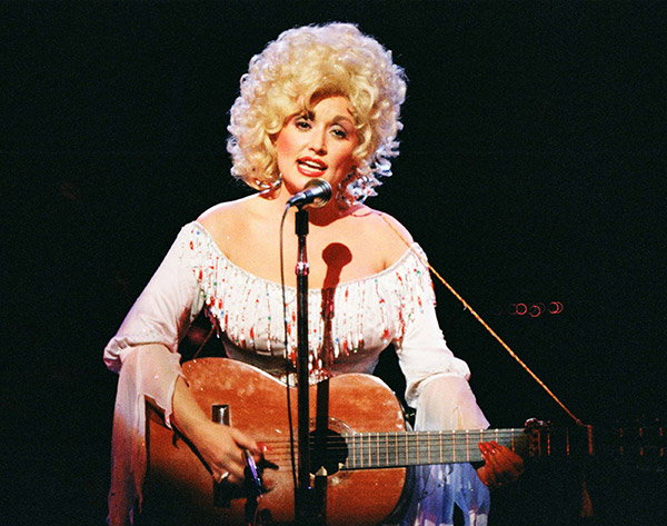 Dolly Parton performs with an acoustic guitar on stage in London in 1983.
