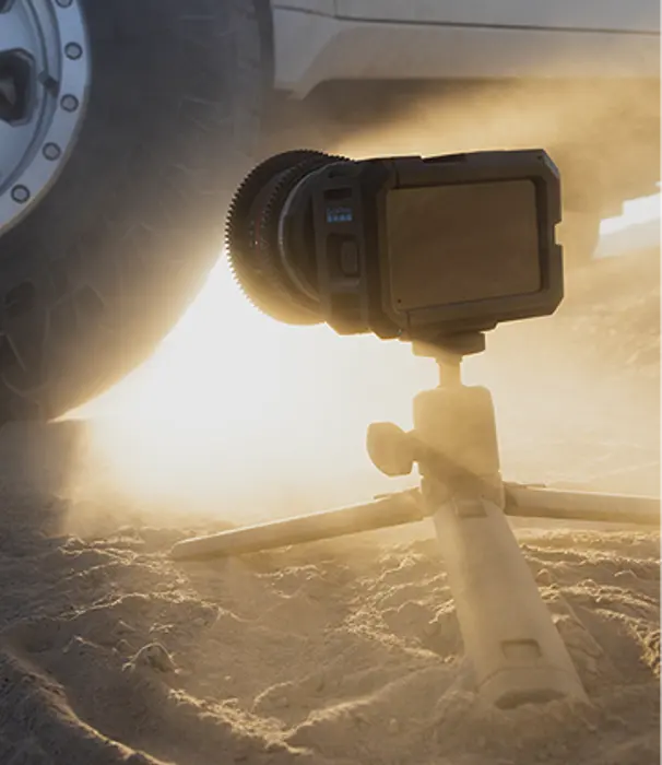 GoPro camera on a tripod in the sand.
