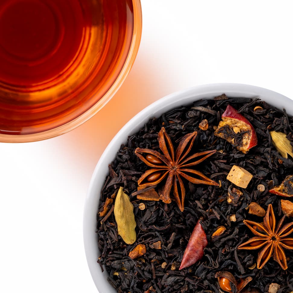 Mound of loose leaf caramel apple chai tea next to a brewed cup