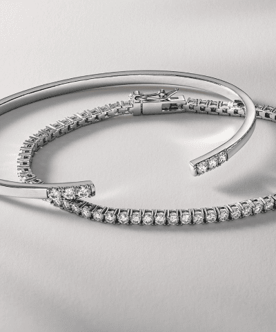 White gold diamond tennis bracelet and diamond-accented open cuff bracelet.