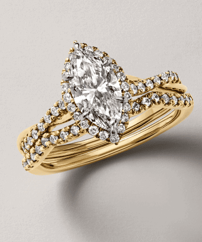 Yellow gold marquise diamond ring with halo and split-shank diamond band.