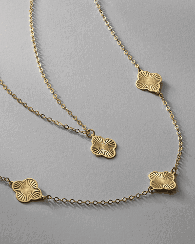 Yellow gold necklaces with textured four-leaf clover motifs.