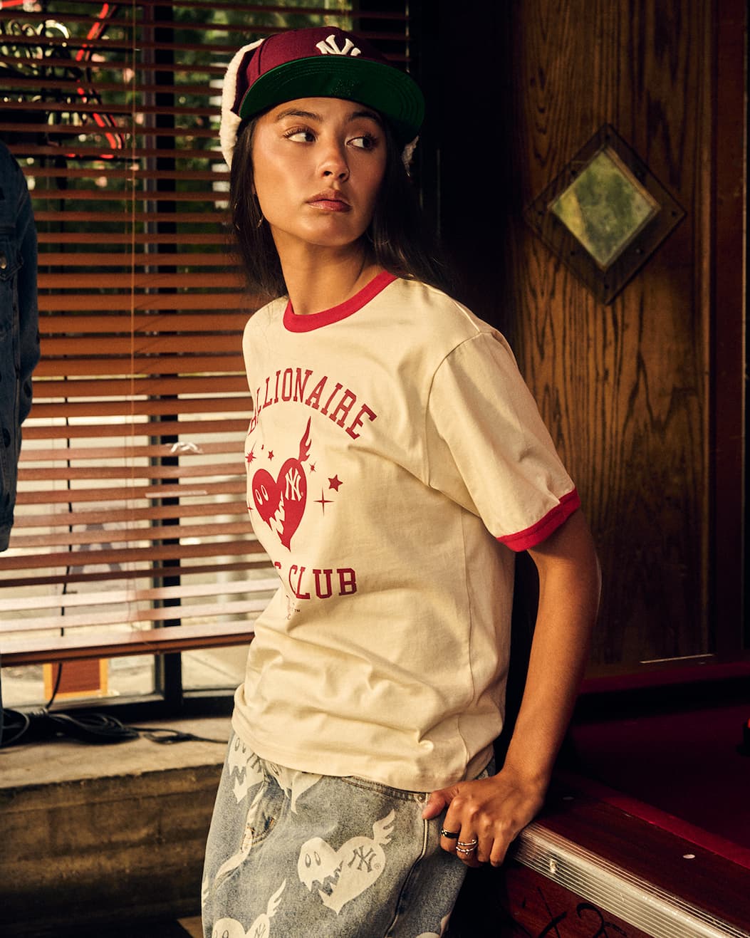 Female model wearing New York Yankees™ | Billionaire Boys Club Women's Ringer Tee, Trapper Hat, and Women's Denim Shorts