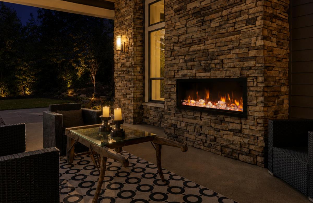 Outdoor patio with fireplace and seating at night.