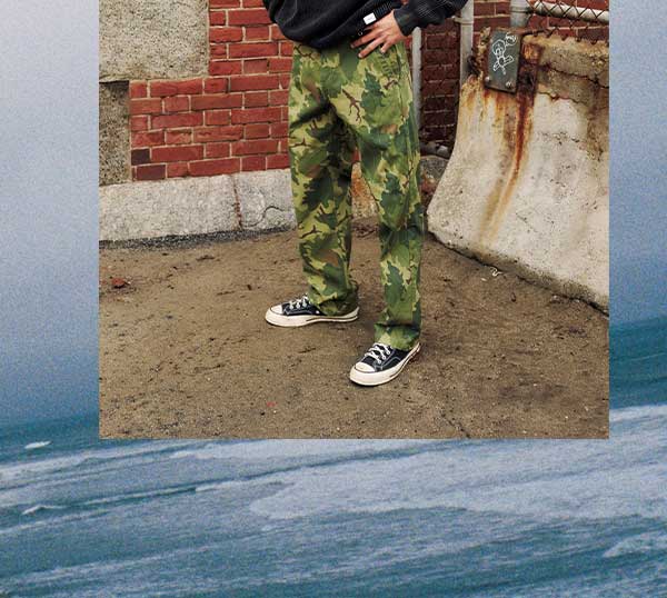 Man in black Swell Sweater and Camo Deck Pant