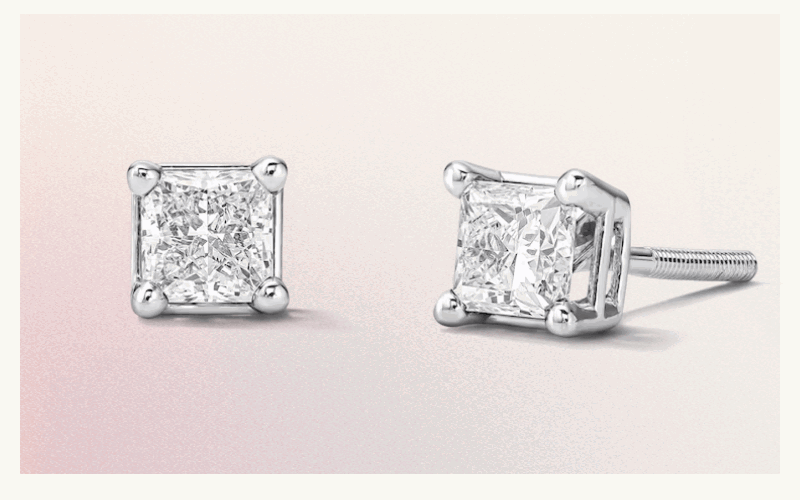 Pair of princess-cut diamond studs in white metal four-prong basket setting.
