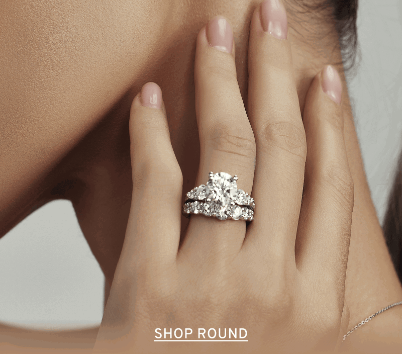 Close-up of engagement and wedding ring stack on hand. Click to Shop Round