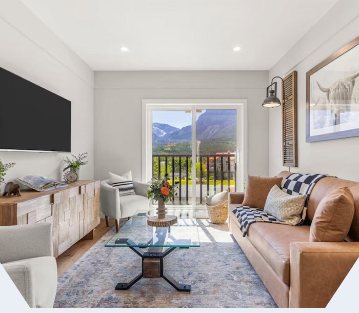 Sunlit mountain-view retreat with cozy interiors and a balcony framing Alberta's rugged peaks.