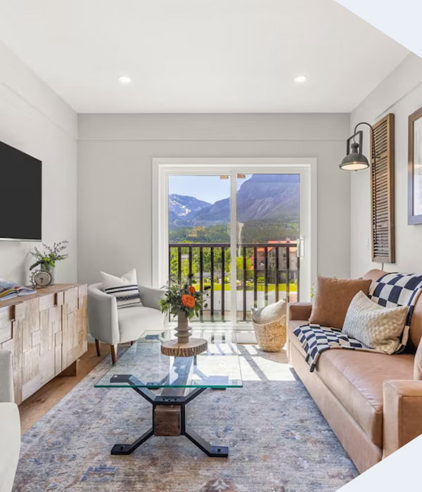 Sunlit mountain-view retreat with cozy interiors and a balcony framing Alberta's rugged peaks.