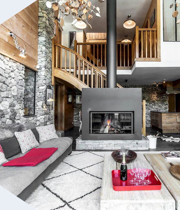 Stone-clad alpine retreat with soaring ceilings, a crackling hearth, and warm timber details inviting connection.
